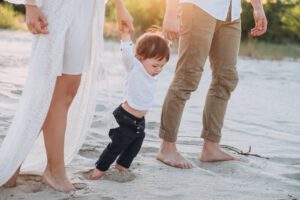 couple walking young child on beach experiencing secondary infertility