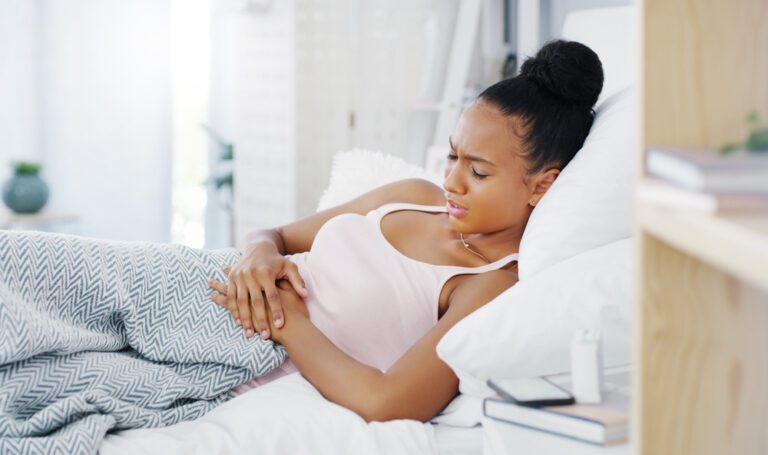woman with endometriosis holding her abdomen